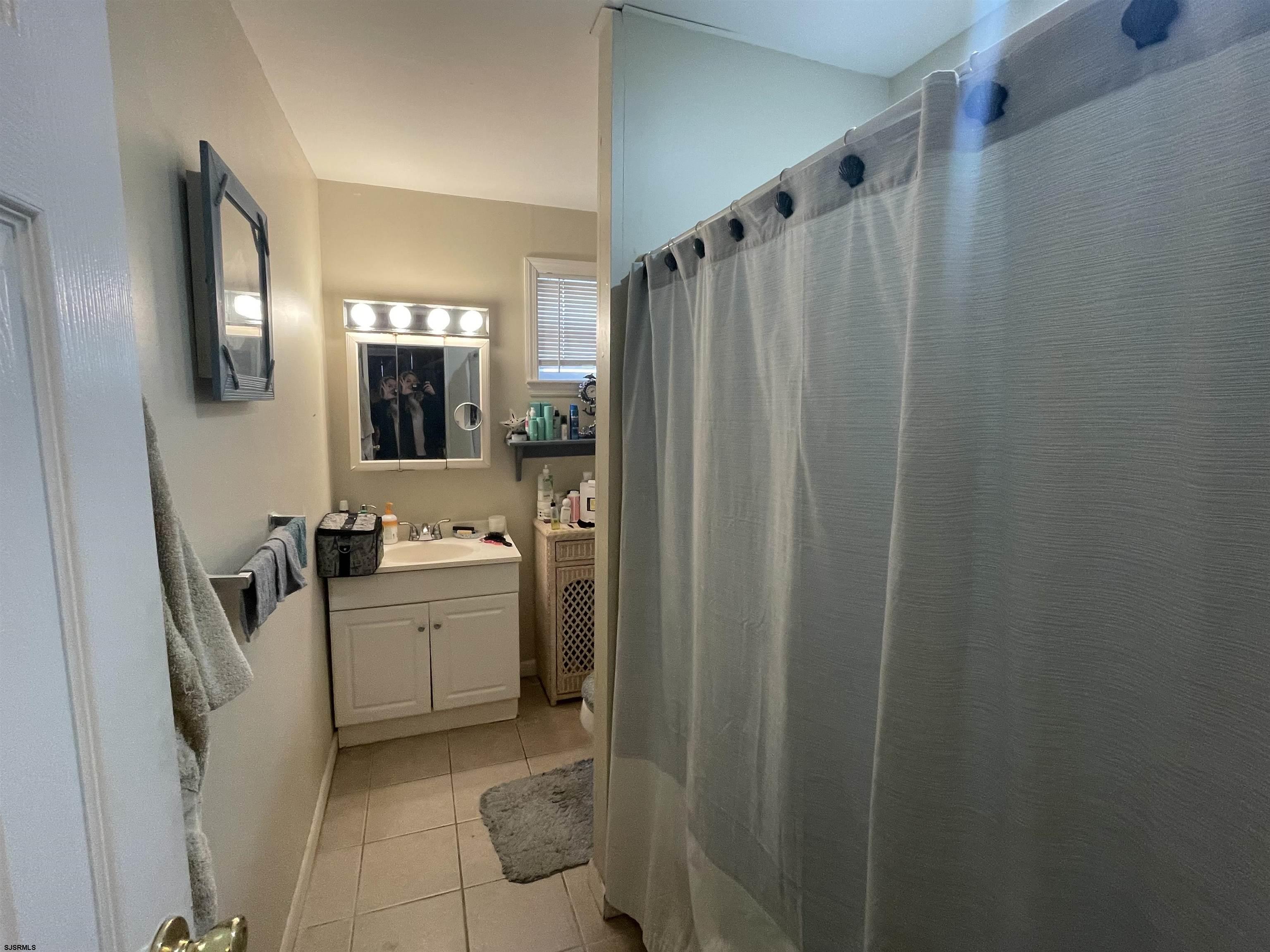 4901 Harbor Beach Boulevard, Unit P8 Brigantine, NJ 08203 - Photo 13 of 39 a bathroom with sink a mirror a bathtub and shower