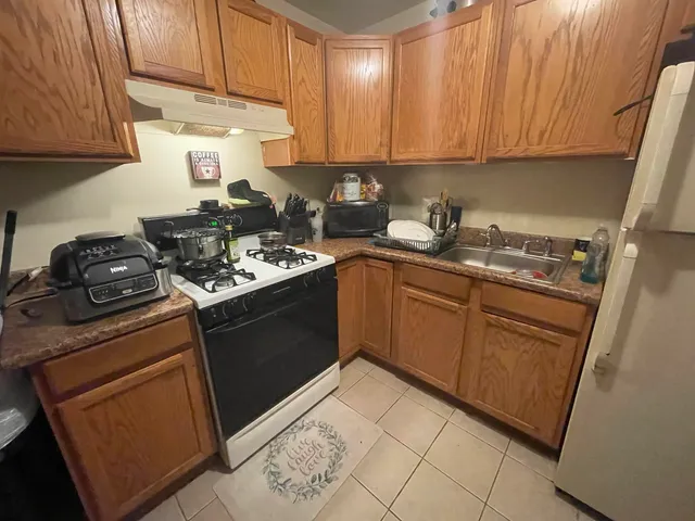 a kitchen with stainless steel appliances granite countertop a stove sink and cabinets