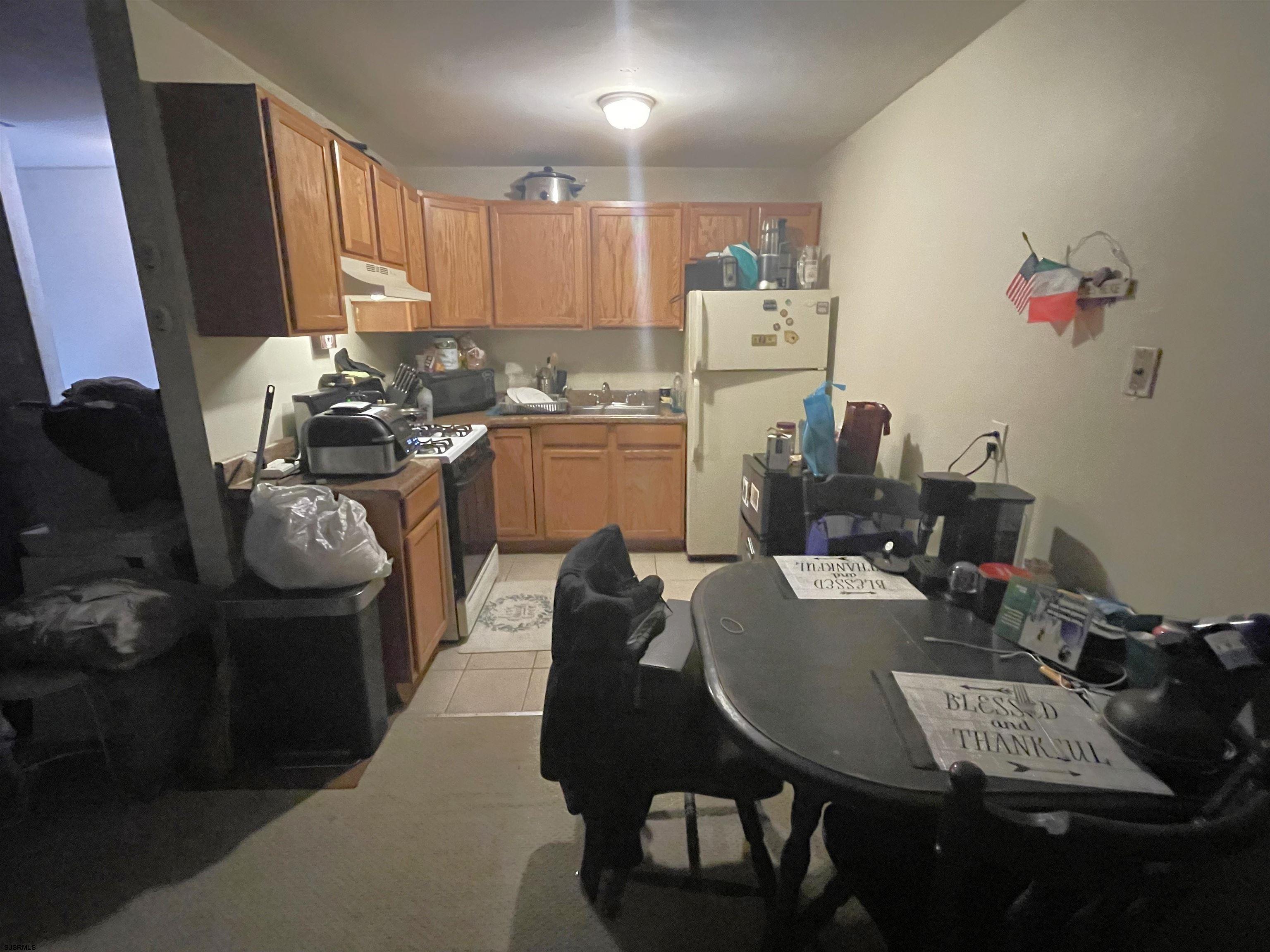 4901 Harbor Beach Boulevard, Unit P8 Brigantine, NJ 08203 - Photo 7 of 39 a kitchen with a refrigerator a stove a sink dishwasher and white cabinets with wooden floor