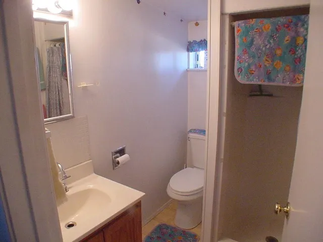 a white toilet sitting next to a bathroom sink