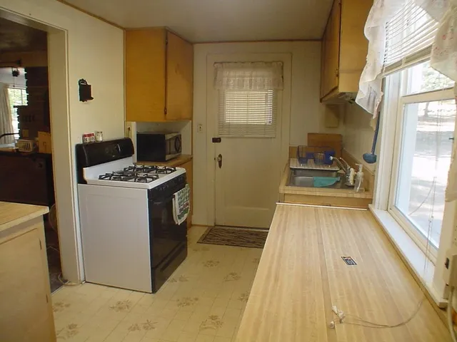 a kitchen with a sink a stove top oven a counter space and cabinets