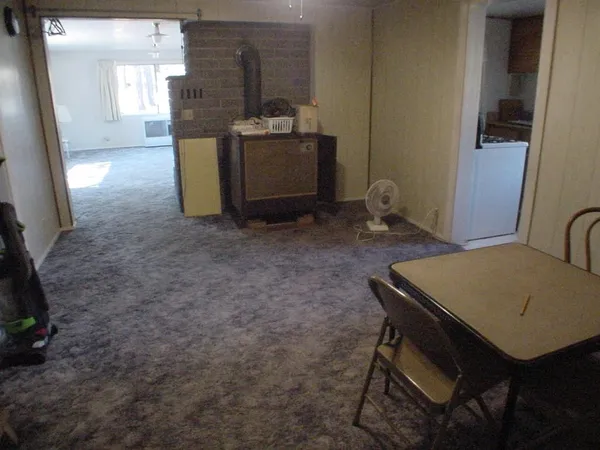 a room with furniture a rug and a refrigerator