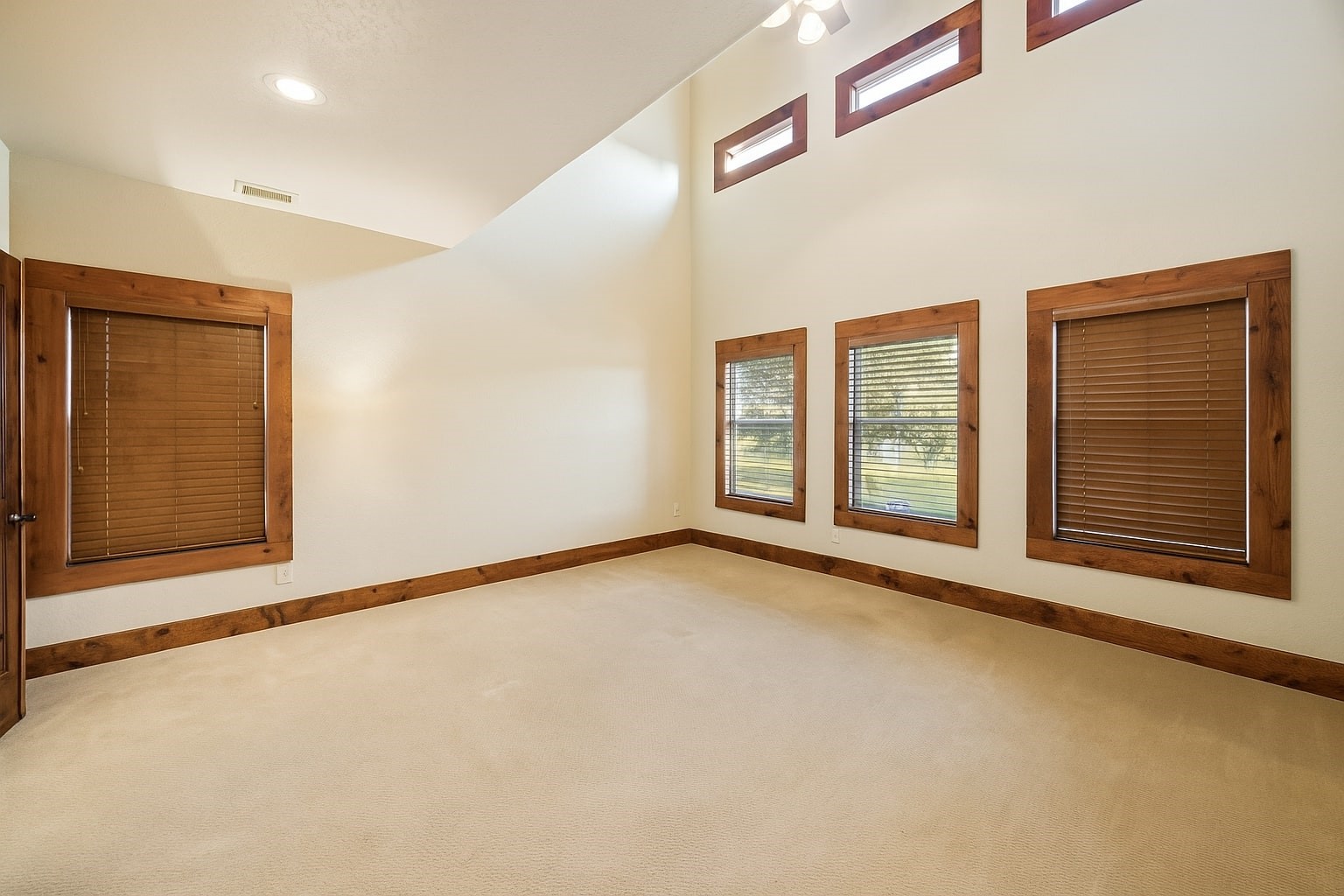 40570 Wildlife Run Hempstead, TX 77445 - Photo 14 of 43 Retreat to a true Texas-style primary suite with soaring ceilings, custom wood furnishings, and peaceful pasture views. Light floods through high-set clerestory windows and three full-sized windows, creating a warm and tranquil space. Virtually decluttered to help visualize potential use.