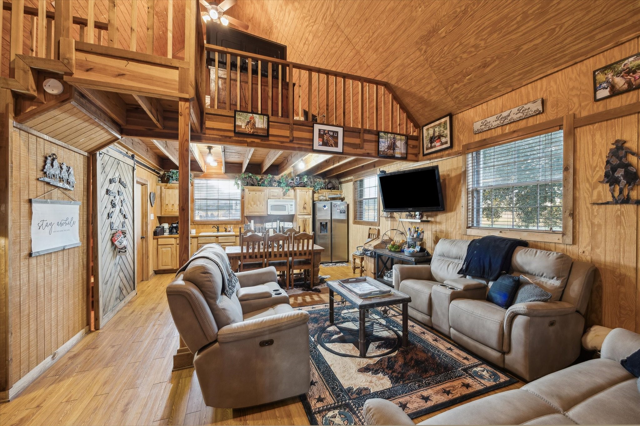 40570 Wildlife Run Hempstead, TX 77445 - Photo 27 of 43 Vaulted wood ceilings, warm paneling, and an open loft give this cozy guest house its cabin-in-thecountry charm. With plush
recliners, dining space, and a full kitchen, it’s perfect for visitors, extended family, or a separate work/play zone.
