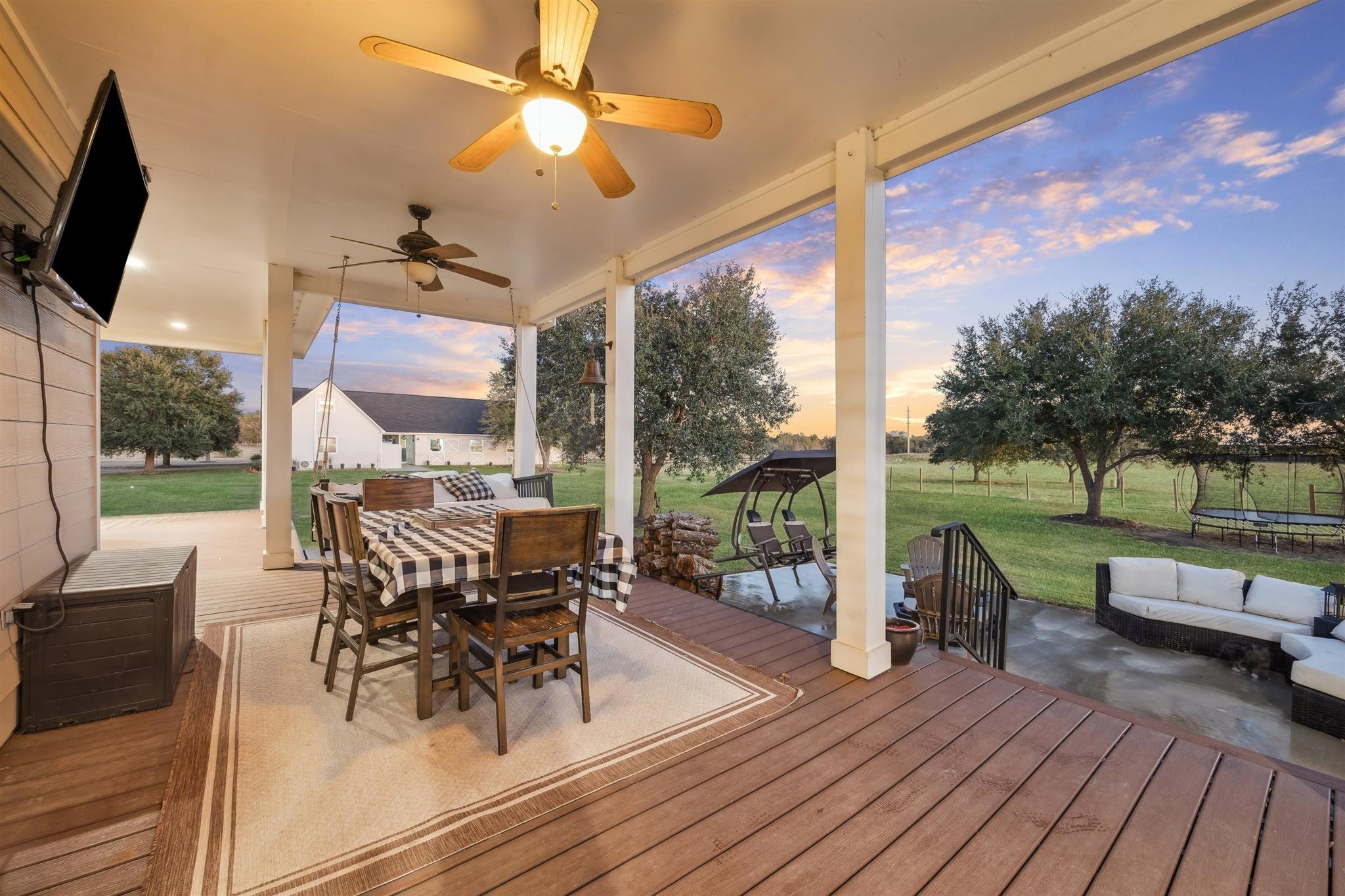40570 Wildlife Run Hempstead, TX 77445 - Photo 32 of 43 This covered deck doubles as an open-air dining room, complete with overhead fans, rustic string lights, and a checkered tablecloth that adds down-home flair. Steps away from the yard, it invites meals under the stars and breezy mornings with a view.