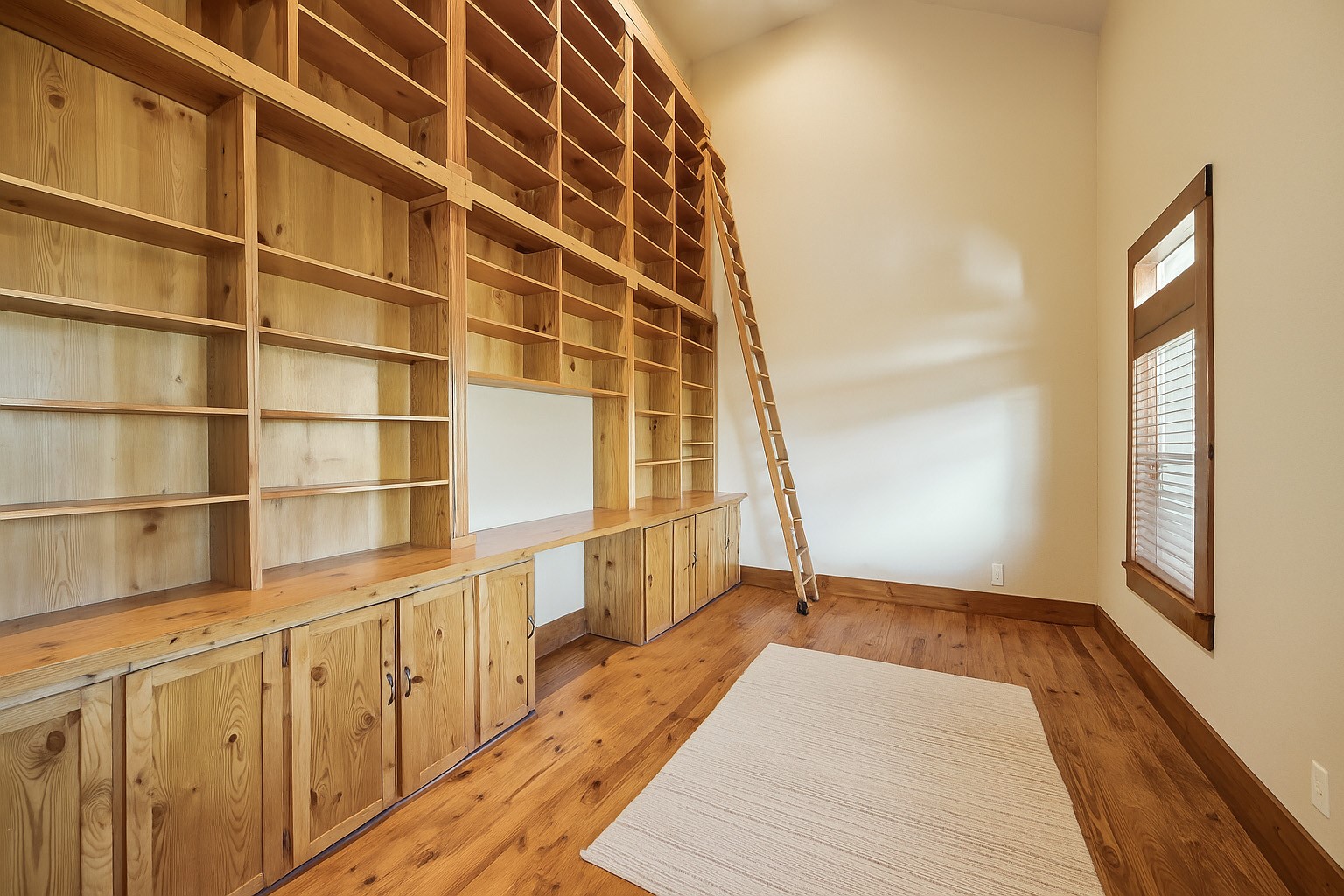 40570 Wildlife Run Hempstead, TX 77445 - Photo 6 of 43 A towering wall of custom built-ins, rolling library ladder, and spacious desk area make this home office a book-lover’s dream. Perfect as a learning space, creative studio, or productive work-from-home retreat—cozy, charming, and completely functional. Virtually decluttered to help visualize potential use.