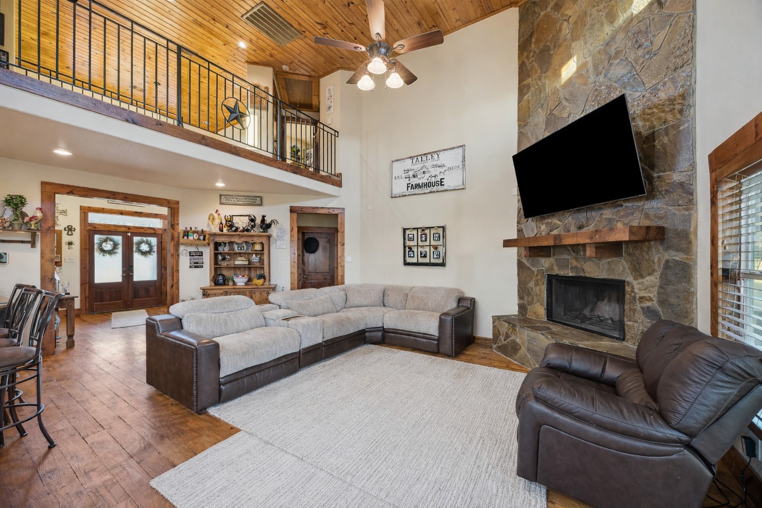 40570 Wildlife Run Hempstead, TX 77445 - Photo 8 of 43 This view from the main entry captures the full scale and flow of the open-concept living room, loft, and entryway. Accents of wood and iron railings, vaulted ceilings, and glowing natural light all combine to showcase the craftsmanship throughout.