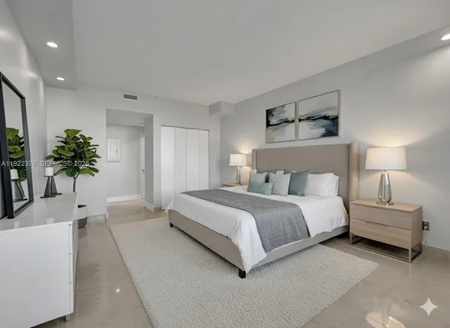 a spacious bedroom with a bed and a potted plant