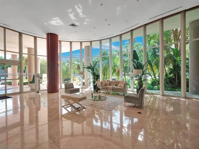 a living room with furniture and a floor to ceiling window