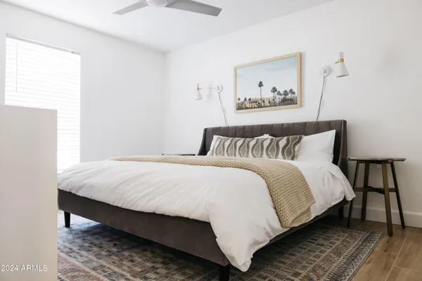 a bedroom with a bed and a painting on the wall