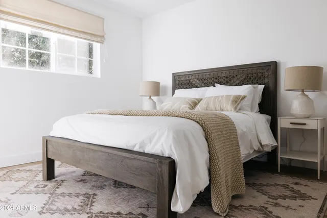 a large bed sitting in a bedroom next to a window