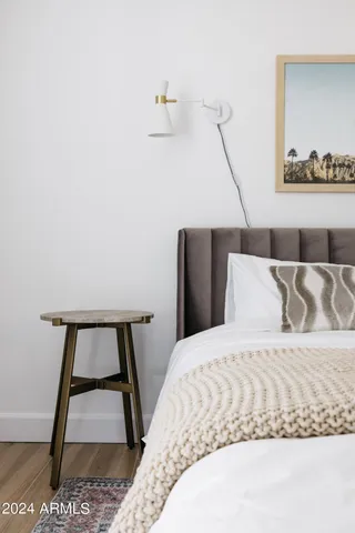 a bedroom with a bed and paintings on the wall