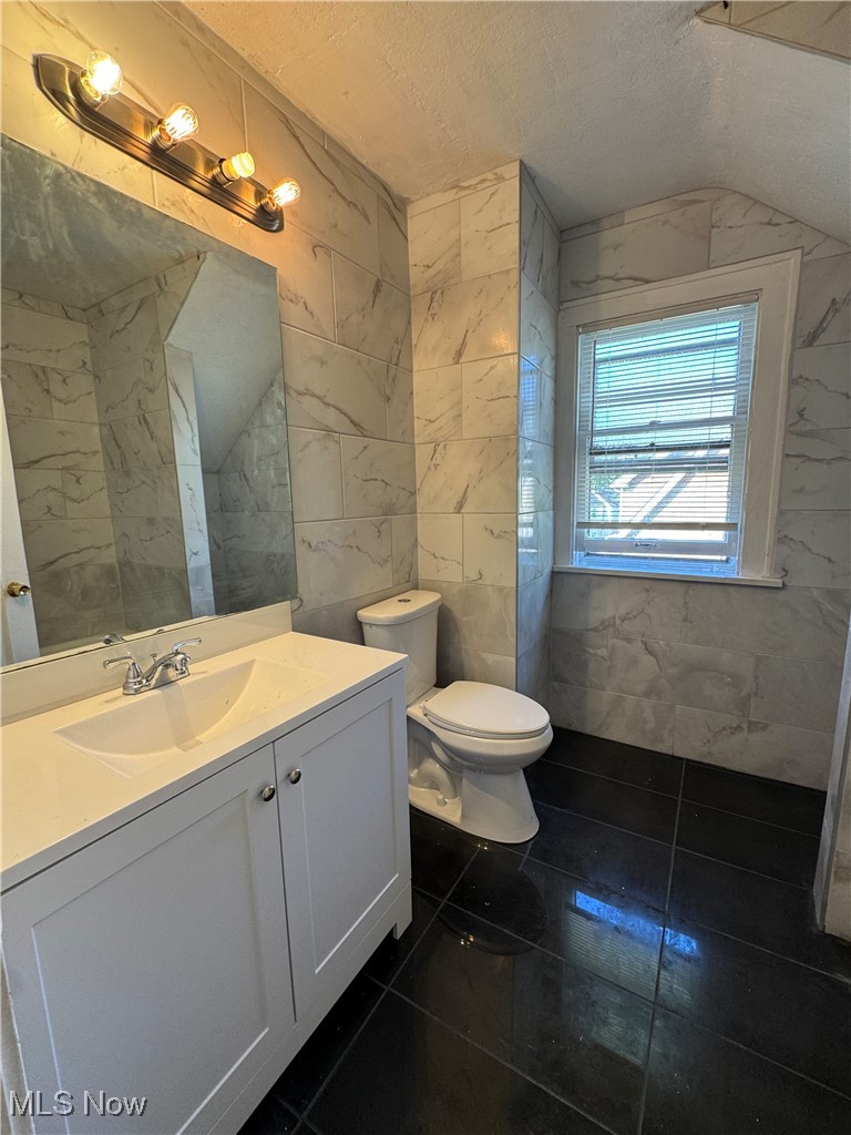 2121 Alton Road Cleveland, OH 44112 - Photo 5 of 44 Bathroom with tile walls, vanity, and a textured ceiling