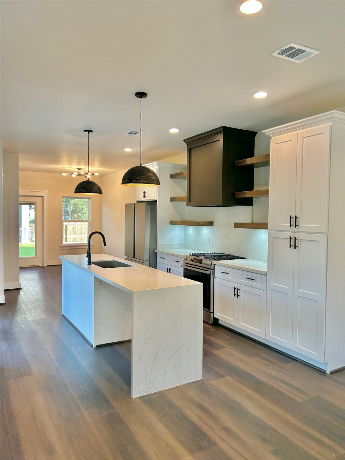 125 4th Street San Leon, TX 77539 - Photo 7 of 40 a large kitchen with stainless steel appliances kitchen island granite countertop a stove a sink a refrigerator and a wooden floors