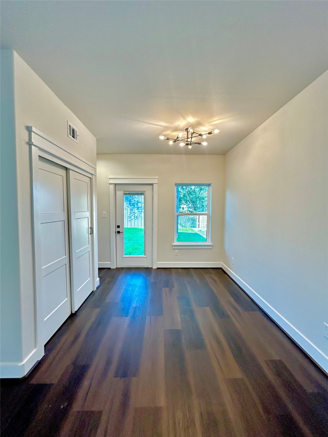 125 4th Street San Leon, TX 77539 - Photo 9 of 40 an empty room with wooden floor chandelier and windows