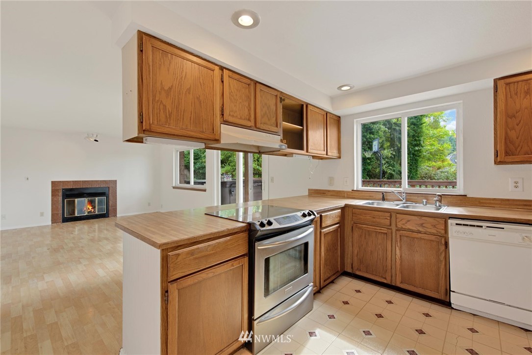 1230 224th Place Southwest Bothell, WA 98021 - Photo 6 of 22 a kitchen with stainless steel appliances granite countertop a sink stove and cabinets