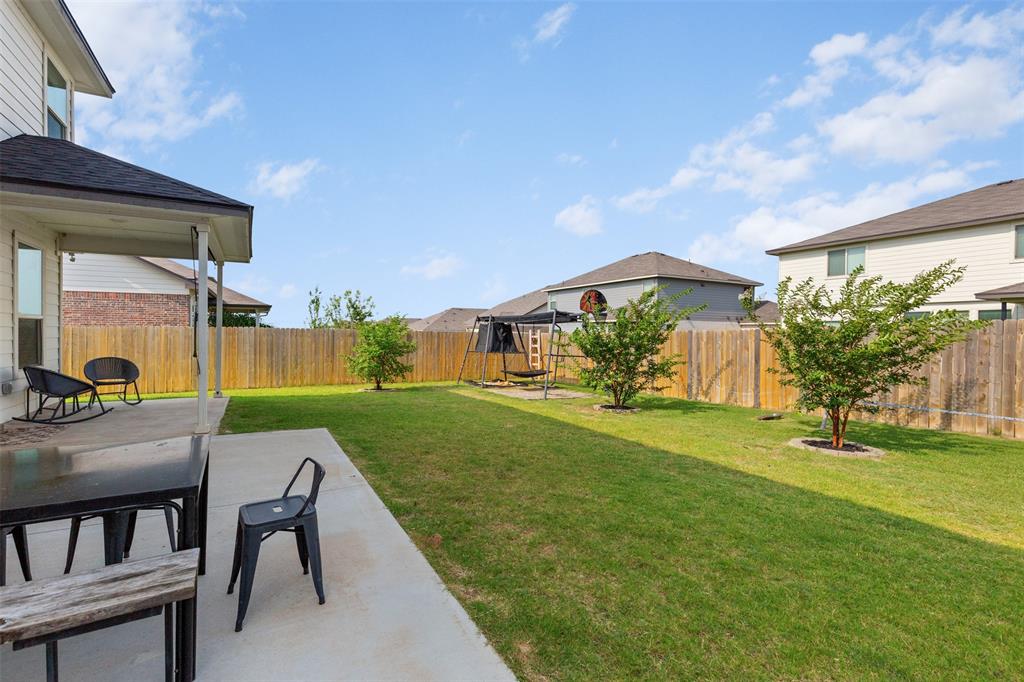 3105 Marston Road Lorena, TX 76655 - Photo 34 of 40 Expansive backyard featuring a covered patio, concrete slab, manicured lawn, and a wood privacy fence