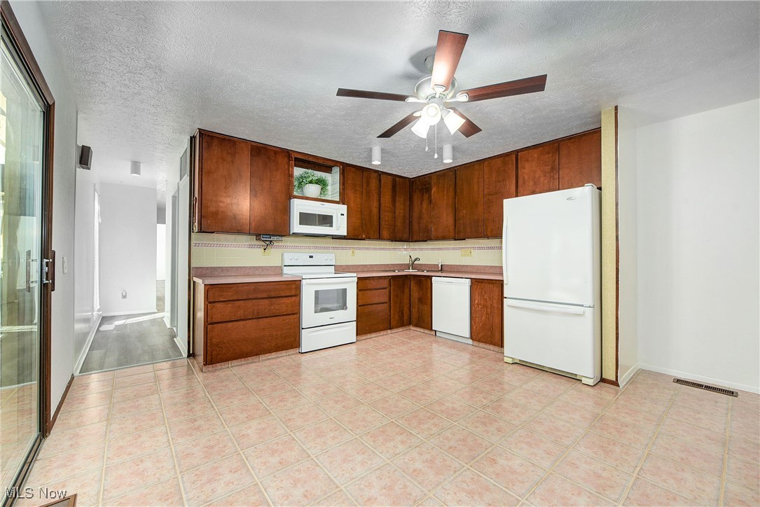 10810 Priem Road Strongsville, OH 44149 - Photo 14 of 35 Kitchen with white appliances, ceiling fan, sink, and a textured ceiling