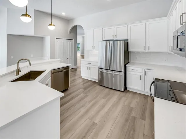 a kitchen with granite countertop a refrigerator stove and sink