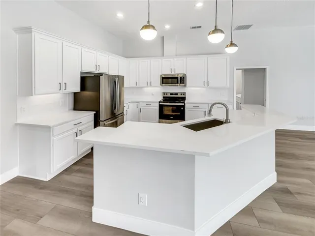 a kitchen with stainless steel appliances a refrigerator sink and microwave