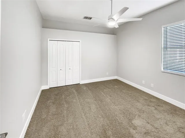 an empty room with a window and a fan