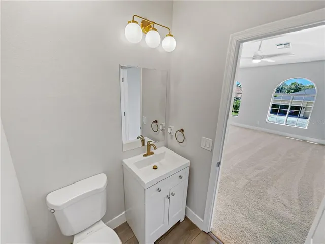 a spacious bathroom with a toilet sink and mirror