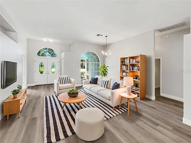 a living room with furniture fireplace and wooden floor