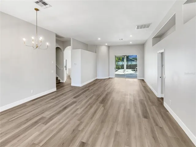 a view of empty room with wooden floor and window