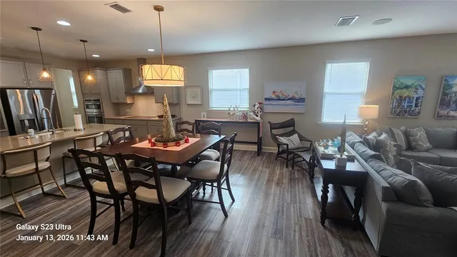 a view of a a dining room with furniture window and wooden floor