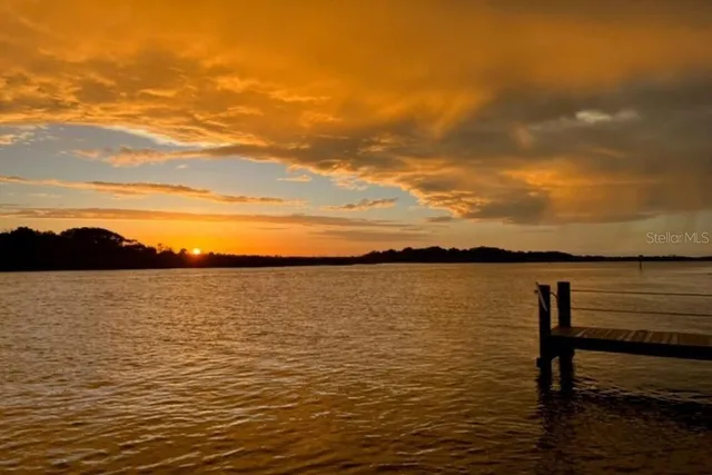 a front view of multi story residential apartment building with a yard and potted plants