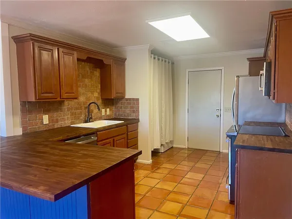 a kitchen with granite countertop a sink stove and refrigerator