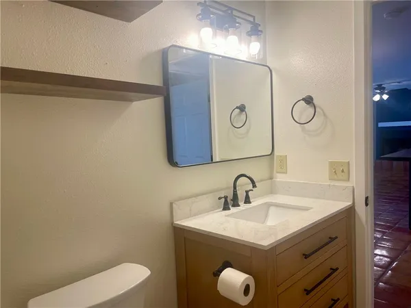 a bathroom with a sink mirror vanity and toilet