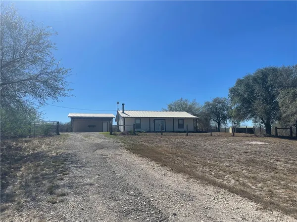 a view of dirt yard with a house