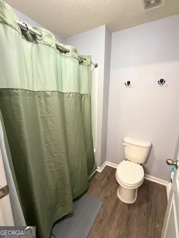 a bathroom with a toilet and a shower curtain