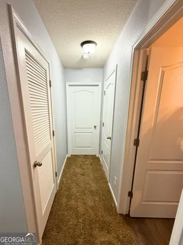a view of a hallway with white walls and stairs