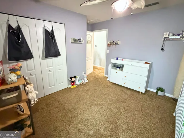 a bedroom with a bed and a flat tv screen on the dresser