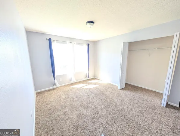 a kitchen with stainless steel appliances kitchen island granite countertop a table chairs and a refrigerator