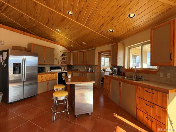 a very nice looking open kitchen with stainless steel appliances granite countertop a refrigerator and wooden cabinets
