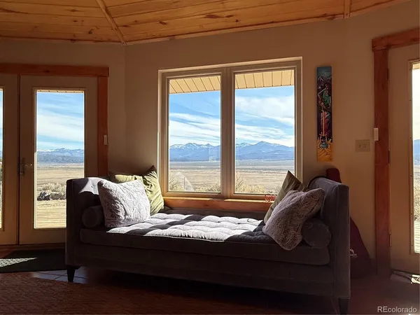a living room with furniture a flat screen tv and a large window