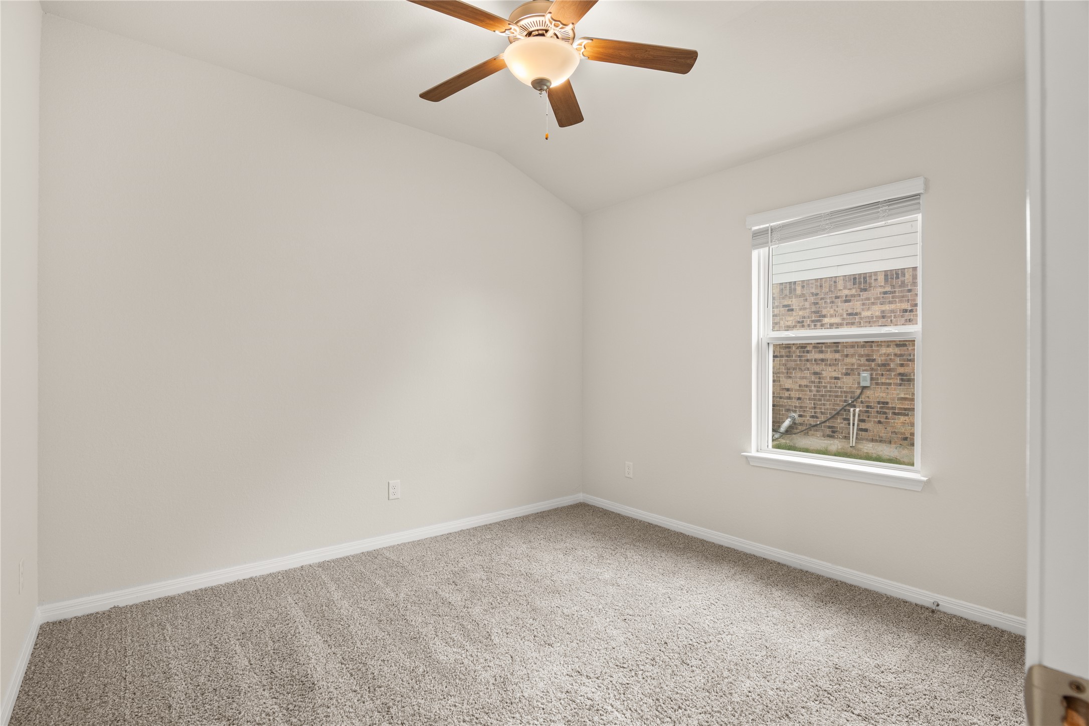 105 Saviano Road Hutto, TX 78634 - Photo 13 of 22 Secondary Bedroom #2: A well-lit secondary bedroom features a ceiling fan and plush carpeting, offering comfort and simplicity.