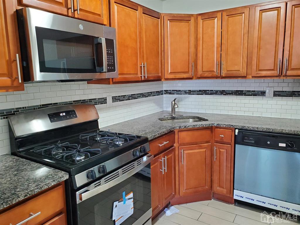 3301 Hana Road Edison, NJ 08817 - Photo 7 of 39 a kitchen with granite countertop cabinets and stainless steel appliances