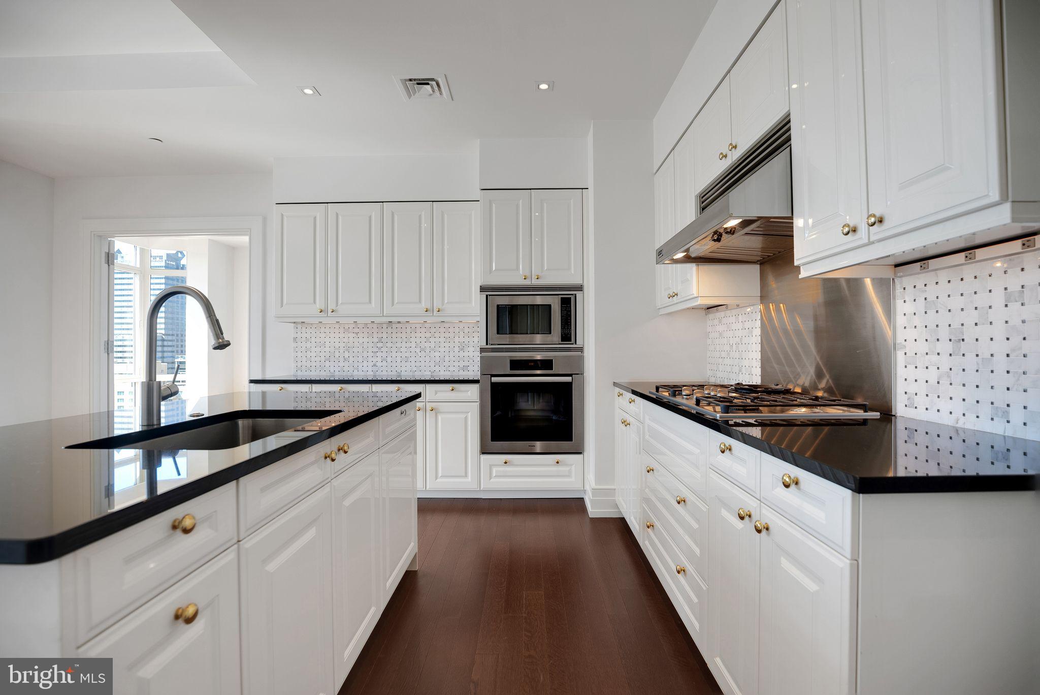 130 South 18th Street, Unit 2801 Philadelphia, PA 19103 - Photo 11 of 51 a large kitchen with stainless steel appliances granite countertop a stove a sink and a refrigerator