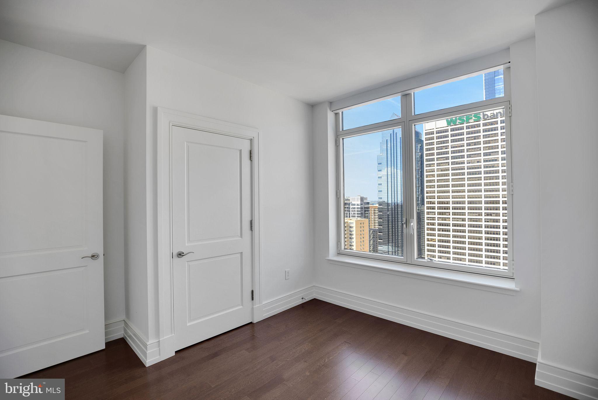 130 South 18th Street, Unit 2801 Philadelphia, PA 19103 - Photo 36 of 51 a view of an empty room with wooden floor and a window