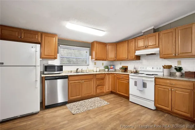 a kitchen with refrigerator cabinets and window