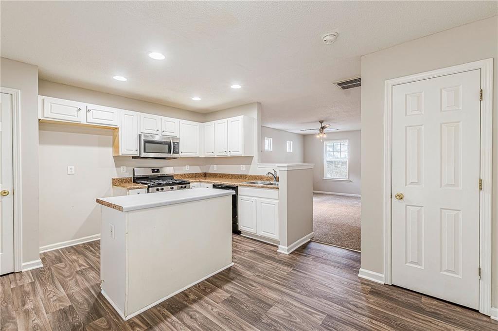 5850 Sable Glen Road Atlanta, GA 30349 - Photo 11 of 33 a kitchen with stainless steel appliances a refrigerator and a stove top oven
