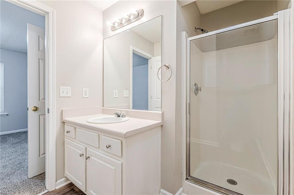 5850 Sable Glen Road Atlanta, GA 30349 - Photo 18 of 33 a bathroom with a sink a mirror a vanity and a shower