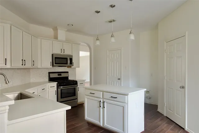 a kitchen with white cabinets and white appliances