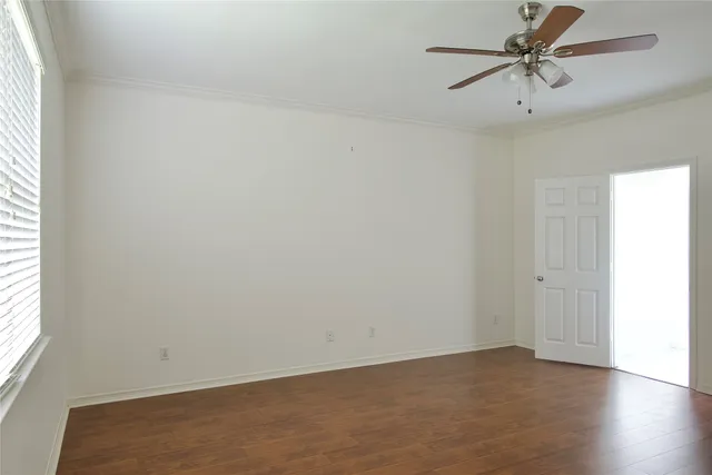 an empty room with a window and a ceiling fan