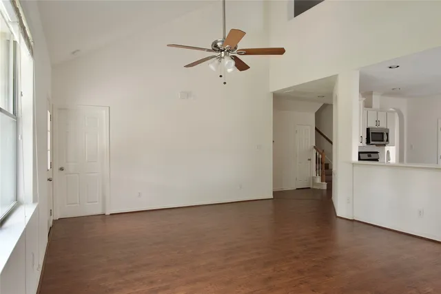 a view of an empty room with window and wooden floor