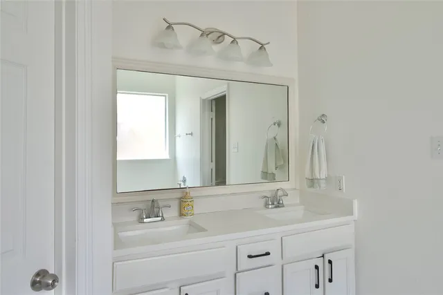 a bathroom with a double vanity sink and a mirror